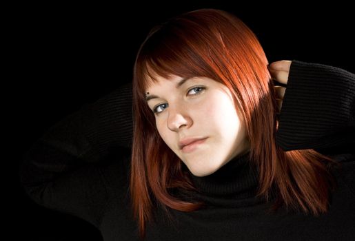 Red hair girl with hands behind head smiling, serene.

Shot in studio.