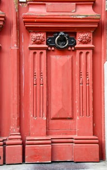 Vintage red wooden door with metal handle details background.