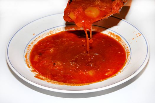 Borsch in a dish with a spoon. Red Russian soup.