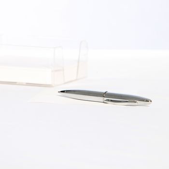 Modern stylish silver ballpoint pen lying angled on a white background with copyspace