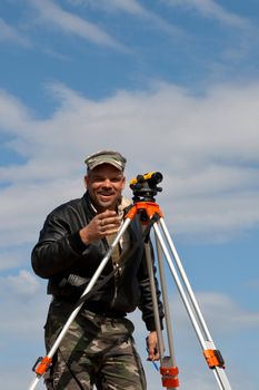 Surveyor measuring land for new street build.