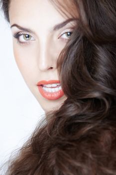 Beautiful lady with perfect makeup and curly hairs on a studio background