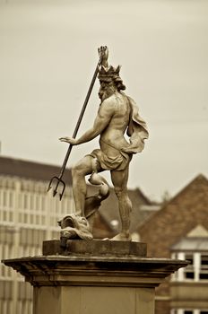 Statue of Zeus in marble and surrounded by buildings, sepia