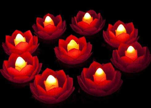 Lighting lotus lamp in dark is a symbol of wisdom overcoming ignorance.