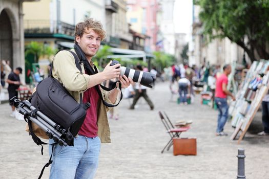 Travel photographer, Havana, Cuba on Plaza de Armas in Old Havana with Camera equipment taking pictures.