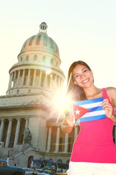 Havana, Cuba - Capitol and tourist with cuban flag in front of the National Capitol Building. Cuba travel concept photo with beautiful smiling happy woman tourist.