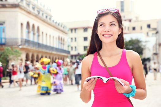 Havana, cuba - tourist with travel guide book on Plaza de Armas, Havana, Cuba. Young woman traveler smiling happy.