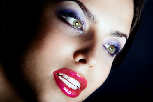Beautiful lady with perfect dramatic makeup on a dark background