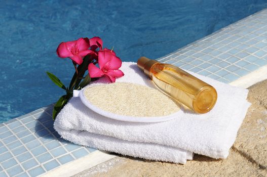 massage oil, shellfish and white towel beside a pool