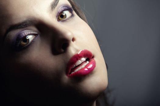 Beautiful lady with perfect dramatic makeup on a dark background