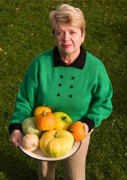 A woman demonstrates grown pumpkins