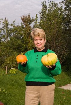 A woman demonstrates grown pumpkins