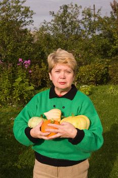 A woman demonstrates grown pumpkins