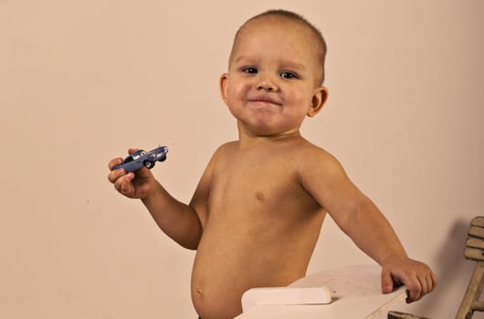 boy is holding a toy car, he is very proud