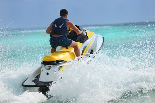 Man on Wave Runner turns fast on the water 