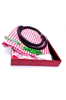 folded muslim hear gear with rosary bead in gift box on white surface