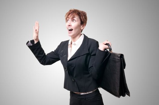 astonished business woman with briefcase on gray background