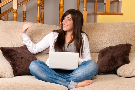 Young woman with laptop call to look portable computer sitting on sofa