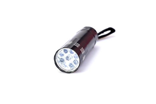 black LED torchlight on white background with LED lights turned on