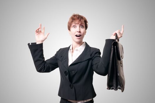 astonished business woman with briefcase on gray background