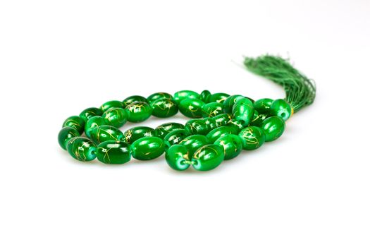 green rosary beads on white background