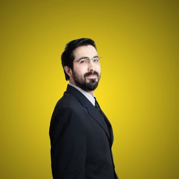 elegant bearded success business man on yellow background