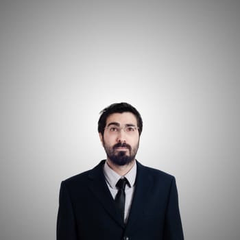 bearded business man looking up on gray background