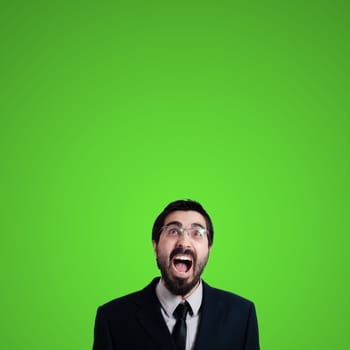 bearded business man looking up on green background