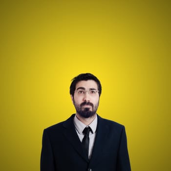 bearded business man looking up on yellow background