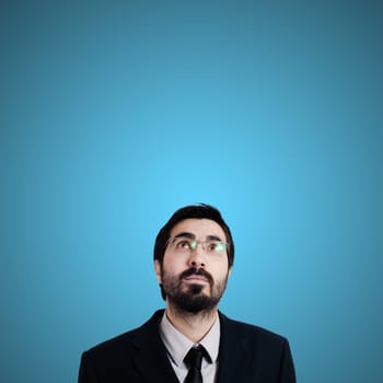 bearded business man looking up on blue background