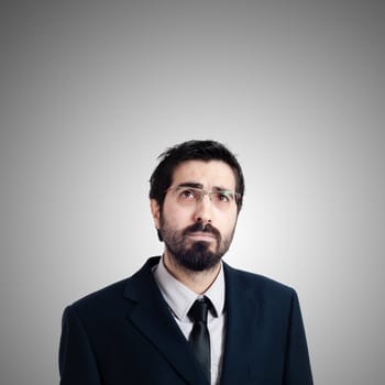 bearded business man looking up on gray background