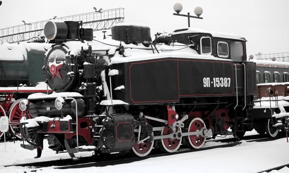 old Soviet locomotive at a train station in winter