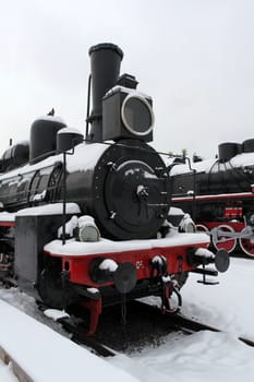 fragment of the old Soviet locomotive at a train station in winter