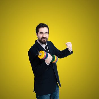 strong business man with weight gym on yellow background
