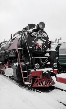 old Soviet locomotive at a train station in winter