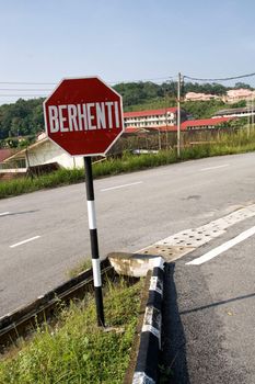 Traffic sign in Malaysia with Malay word Berhenti which means Stop