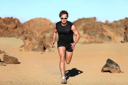 Runner running. Man sprinting in desert training for marathon. Young fit male fitness sport model working out outdoors in amazing desert landscape