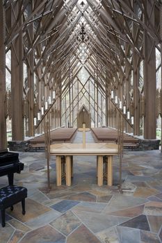 The insides of a wooden and glass church with alter