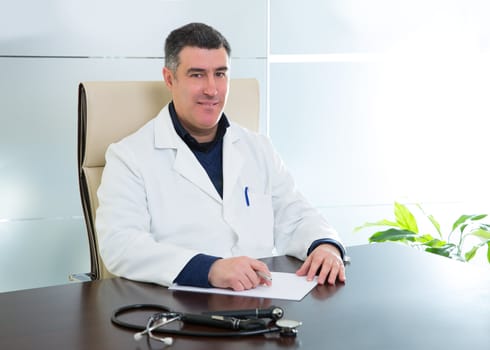 Doctor man expertise sitting in hospital office desk portrait