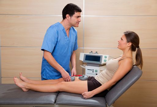 Doctor therapist checking leg muscle electrostimulation to woman patient in hospital