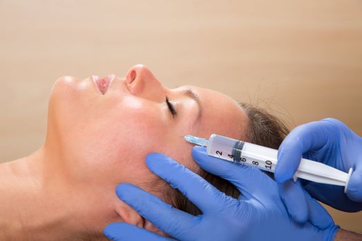 Anti aging facial mesotherapy with syringe closeup on woman face