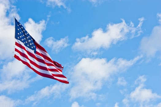 American flag on a blue sky during a windy day