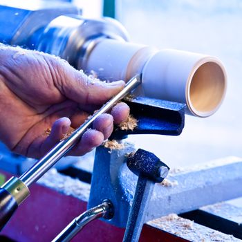 Old worker hands at lathe