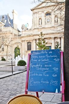 Black board with a menu restaurant in a tipical traditional square in Paris