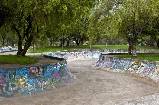 Skateboarding with graffiti in the public gardens in Quito
