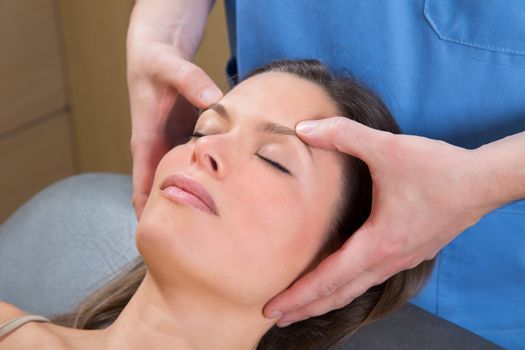 facial massage relaxing therapy on woman face with therapist hands