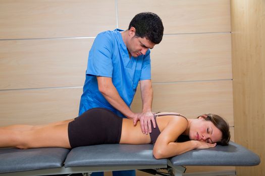 Massage therapy by physiotherapist on back torso to beautiful woman relaxed