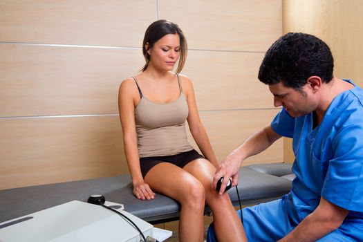 Ultrasonic therapy machine treatment doctor and woman patient on her knee