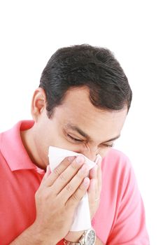 Young man with a cold blowing nose on tissue