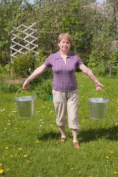 The rural woman with a bucket in hands
